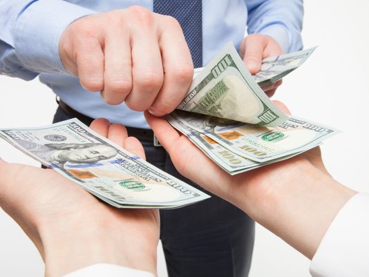 A man giving money to another man