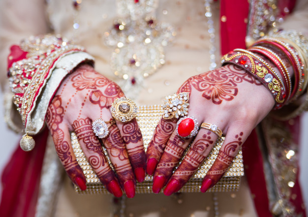 hands showing rings and jewelry with clutch-Can You Make Wudu With Henna On?