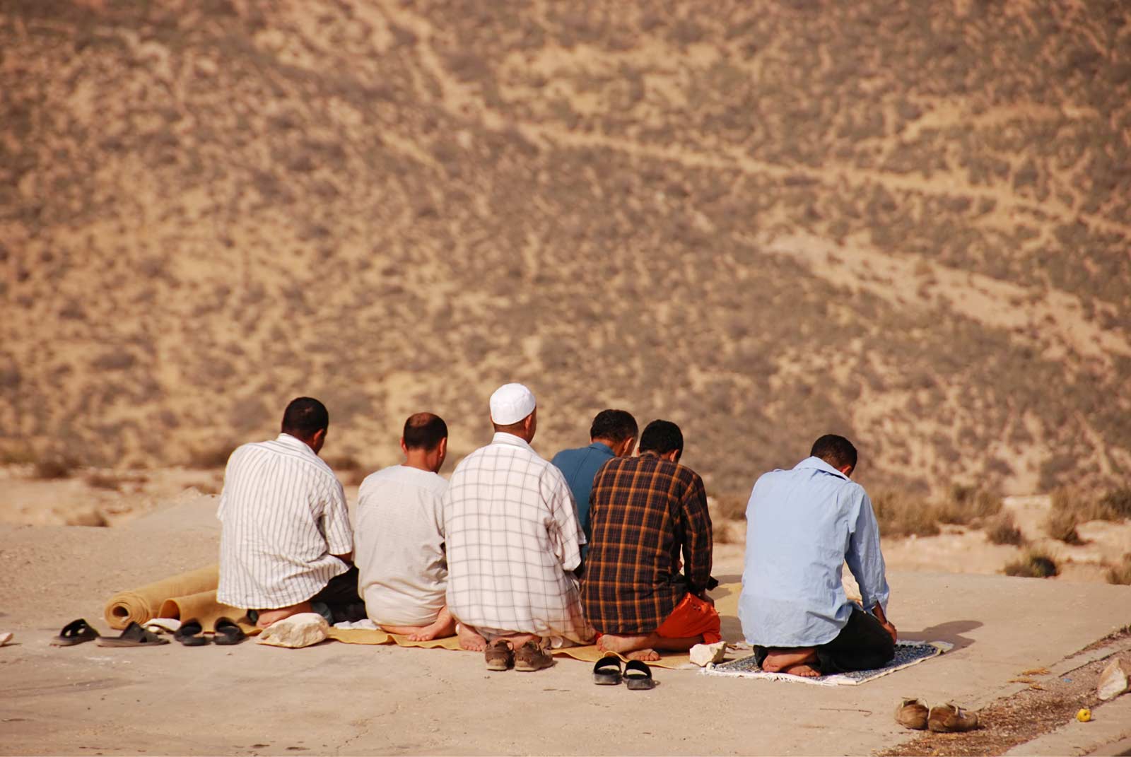 Group of Muslims praying in desert
