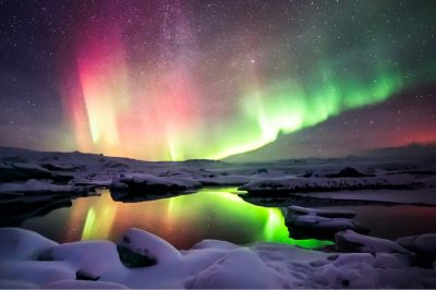 A beautiful green and red aurora dancing over the Jokulsarlon lagoon