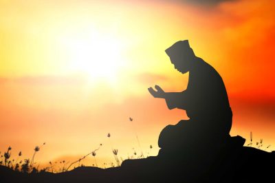 Repent concept: Silhouette Muslim man sitting and praying